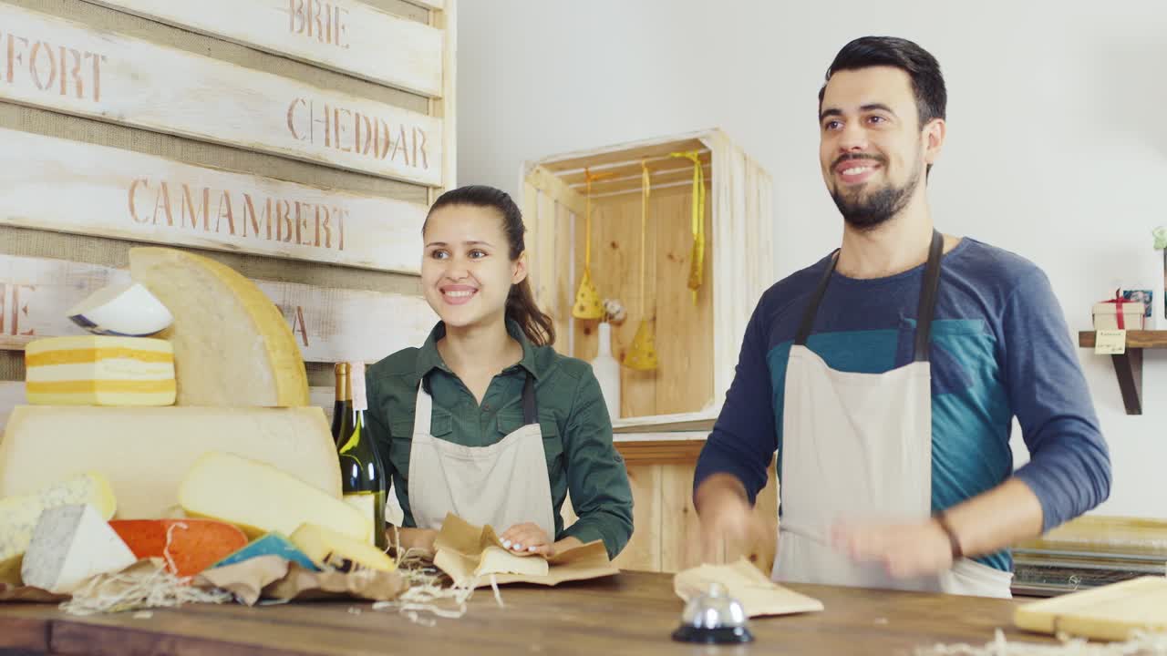 Una mujer compra queso en una pequeña tienda familiar. Concepto de pequeña empresa