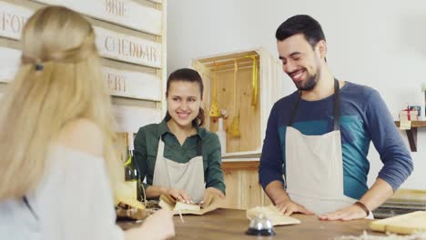 a woman buys cheese in a small family store small business concept