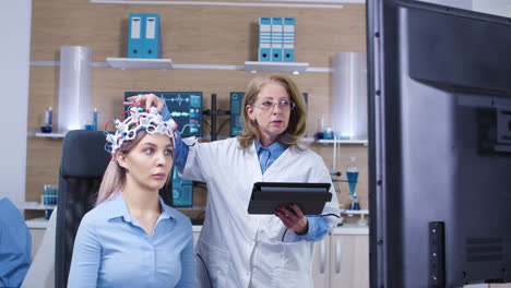 tomada de muñeco de una doctora chequeando la actividad cerebral de su paciente