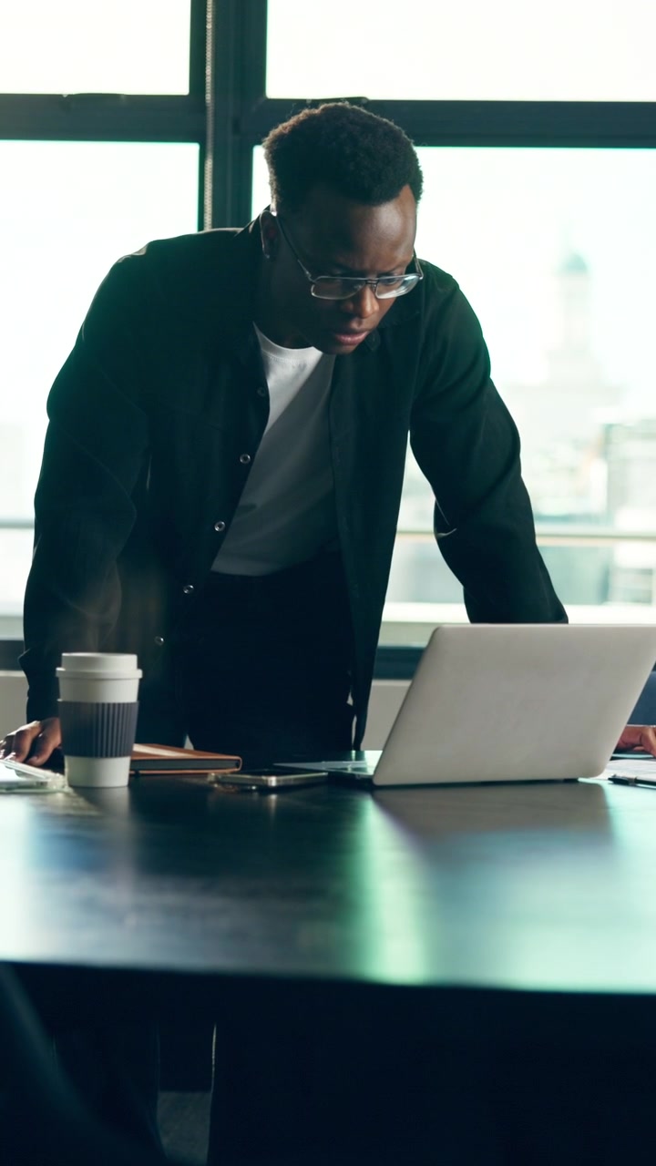 Focused Businessman Working on Laptop in Modern Office