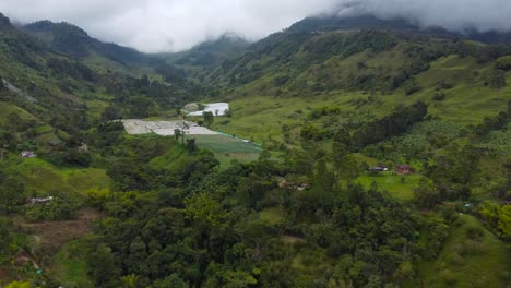 volando el dron a través de un paisaje en colombia con montañas cubiertas por nubes y pequeños campos