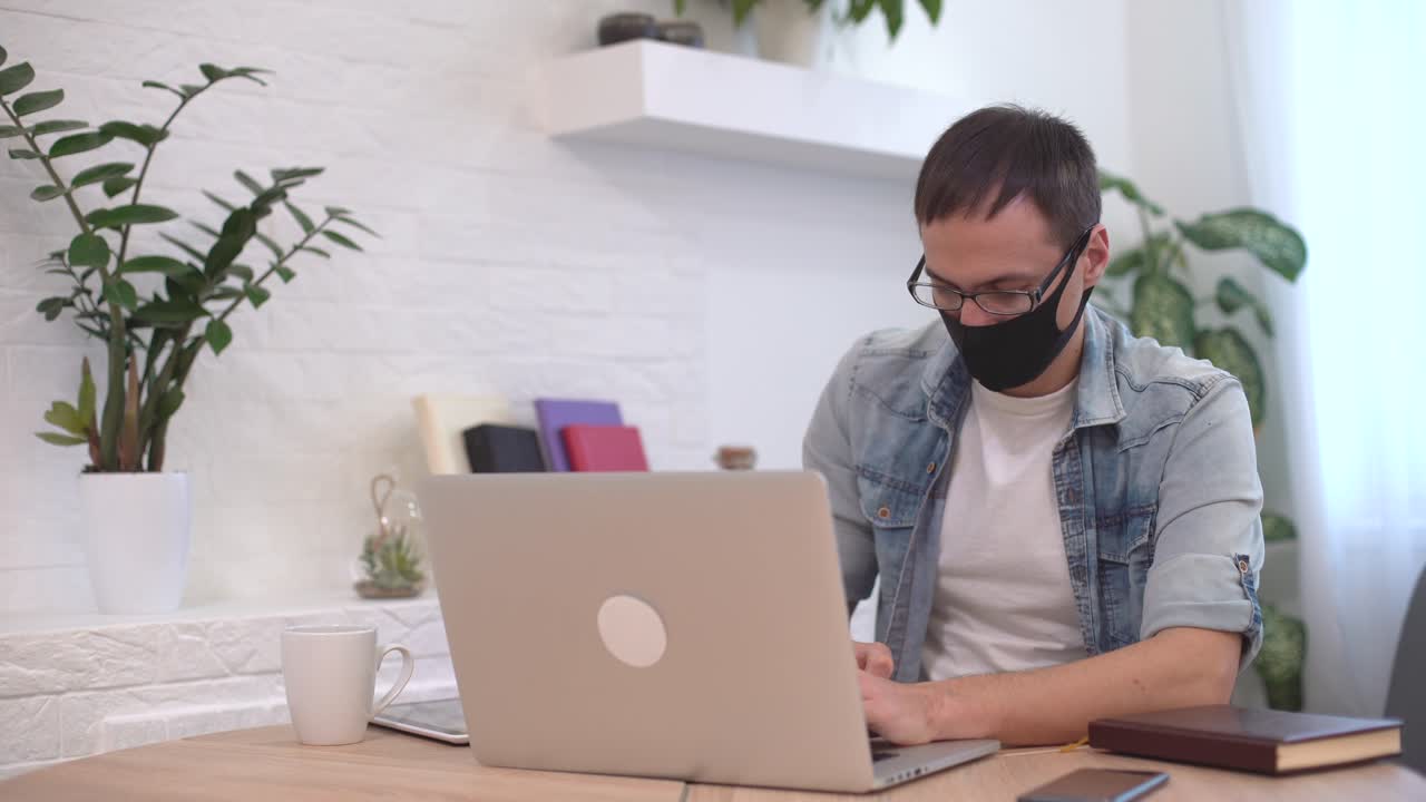 Coronavírus e Coronacrise. Homem estressado ao laptop, massageando as têmporas, com problemas de negócios, sentado em casa.