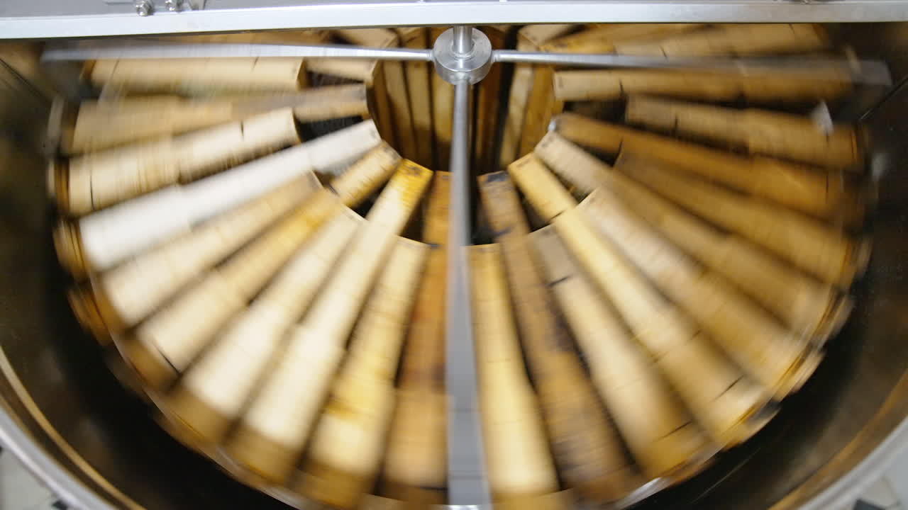 Working honey harvesting apparatus. Honey frames placed in circle are spinning in the centrifuge machine to extract healthy product.