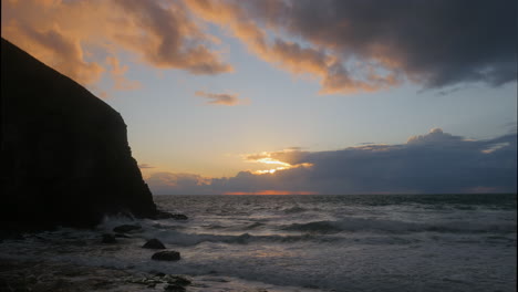 Seascape-view-of-early-autumn-tide-with-beautiful-skies-and-waves-crashing-against-rocks,-Slow-motion