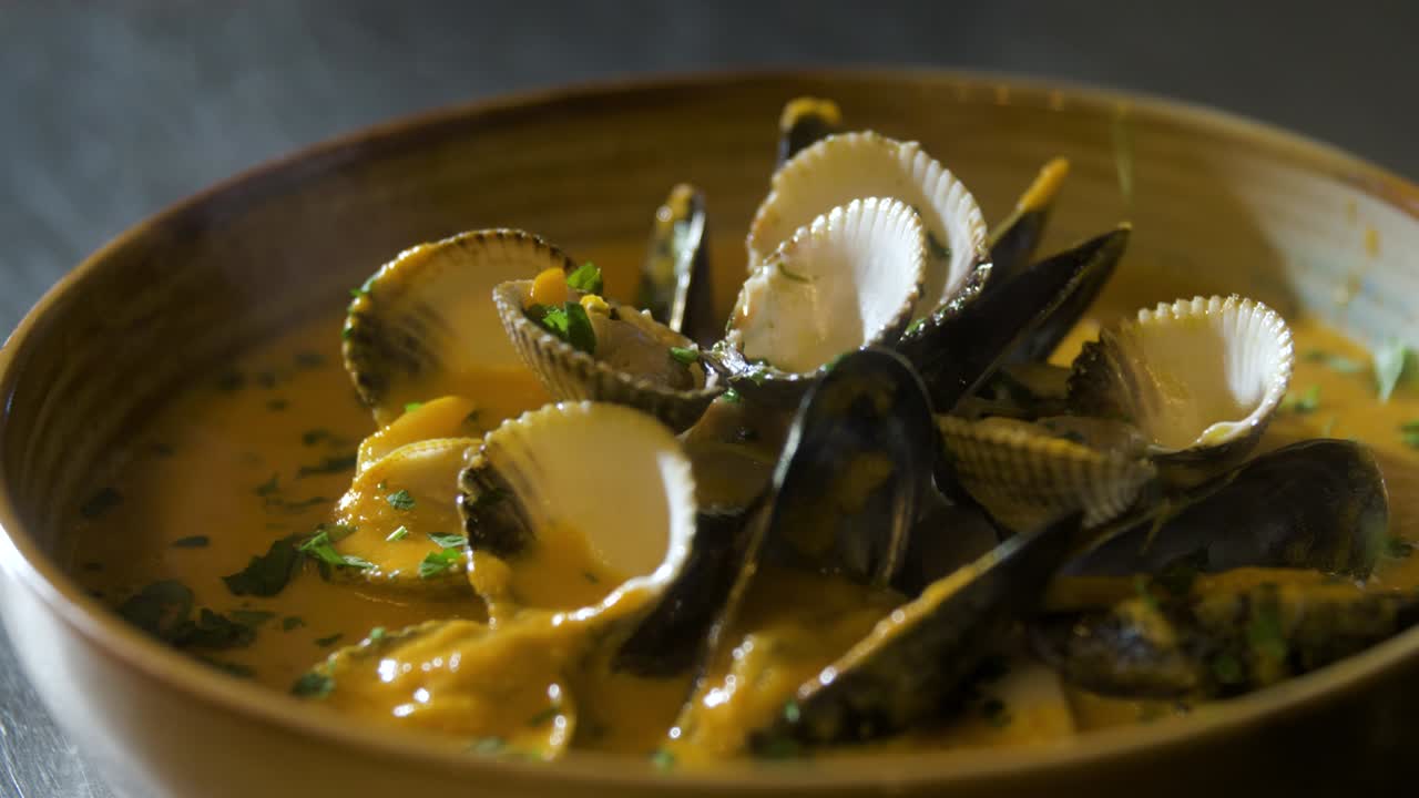 las hierbas se agregan a un plato con mejillones, mariscos