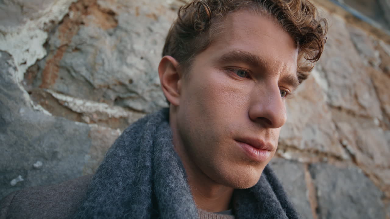Guy tourist leaning wall town building at evening closeup. Man thinking future