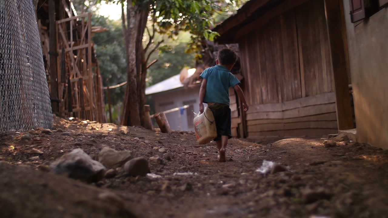 Uma Criança Carrega Água em uma Aldeia Rural