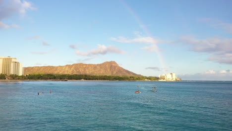rainbow over diamond head with outrigger canoes in waikiki
