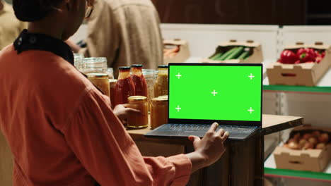 Der-Verkäufer-Blickt-Auf-Den-Greenscreen-Auf-Dem-Laptop,-Während-Er-Die-Ware-Vorbereitet