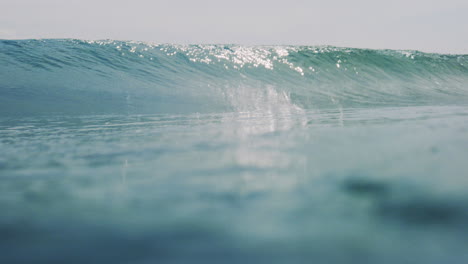 textura verde del agua como las olas del océano brillan de la luz del sol rompiendo soñadoramente