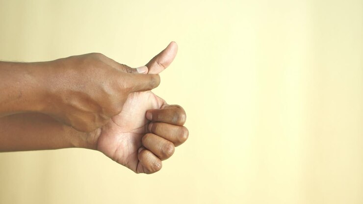 A man's hand giving a thumbs up