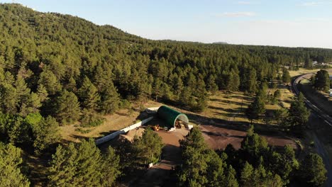 el vuelo de un dron sobre un refugio temporal que alberga un tractor