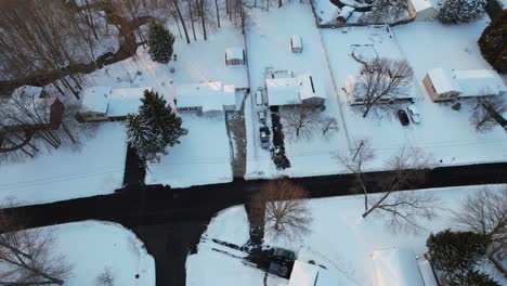 aerial view of a beautiful winter landscape with bare trees colorful small houses in snow, roads, forest and streets