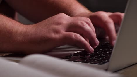 el hombre caucásico trabaja desde casa con una laptop en una mesa de café