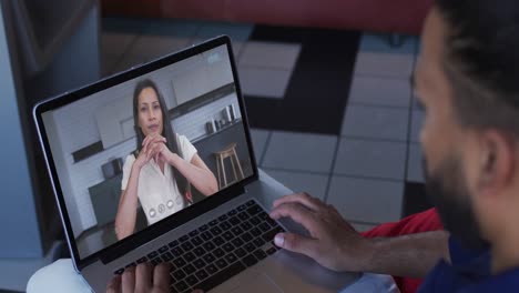 Middle-eastern-man-having-a-video-call-with-female-colleague-on-laptop