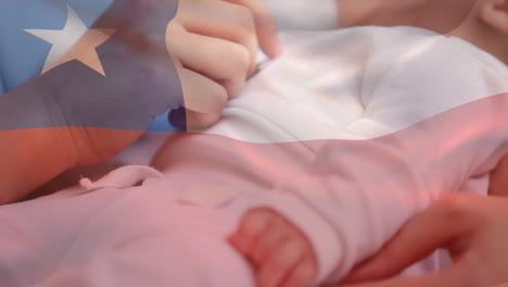 composite video of waving chile flag against mid section of mother holding her baby at home