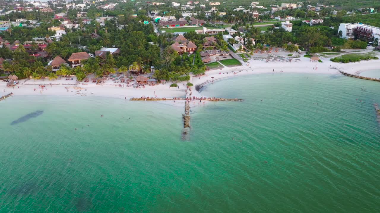 disparo aéreo acercándose a un grupo de personas en un rompeolas en forma de cruz