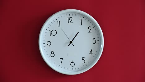 time lapse of white wall clock on red background