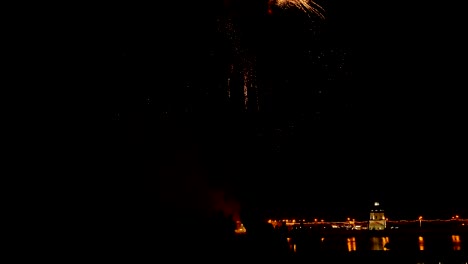 una multitud de personas mira los coloridos fuegos artificiales y celebra.
