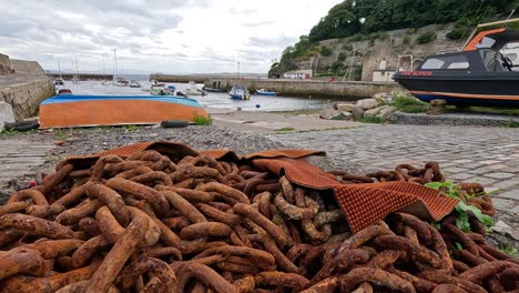 cadenas oxidadas y barcos en el puerto escocés