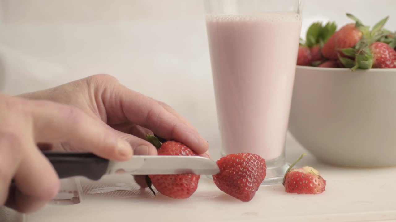Tagliare le fragole a mano per preparare un milkshake alla fragola, campo largo