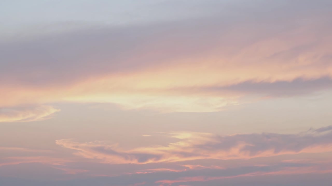 Showing pastel sky responding to sun nearing horizon, shifting layered cloud bands and thin wisps