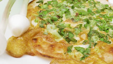 onion pizza on white dish. national cuisine of udmurts: the tabani. onion feathers and tortilla