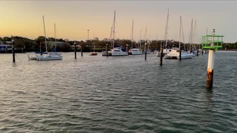 rusty navigation post with flashing green light in the marina at dusk or sunrise