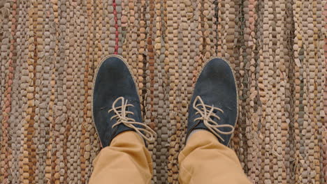 top-view-man-wearing-shoes-enjoying-stylish-footware-standing-on-carpet-rug