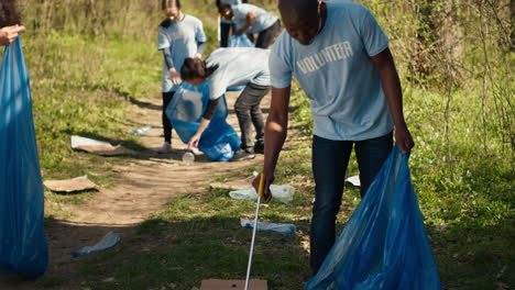 eco friendly activist grabbing garbage and plastic waste from a forest area