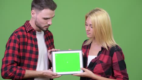 young couple showing digital tablet together