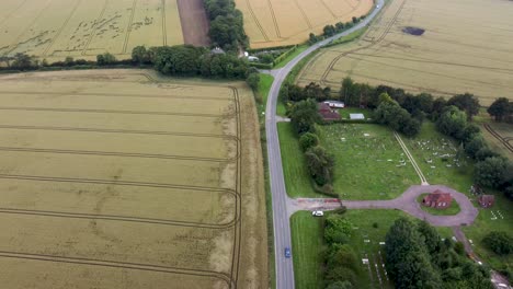 4K-Drohnenvideo,-Das-Eine-Landstraße-Mit-Einem-Friedhof-Daneben-Zeigt