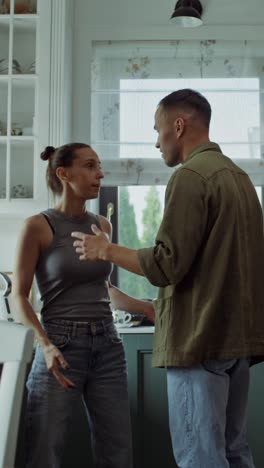 una pareja discutiendo en la cocina.