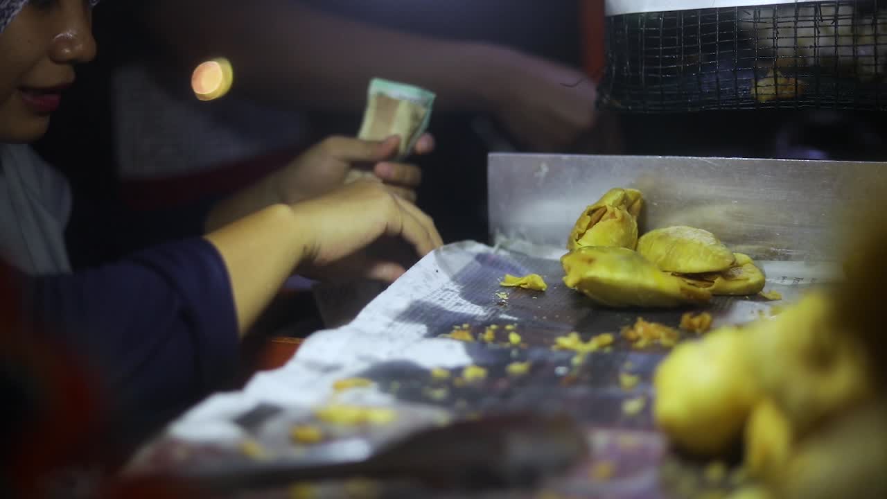 Rekaman seorang penjual kaki lima yang memasak dan menjual makanan gorengan khas Indonesia mereka di jalanan Jakarta