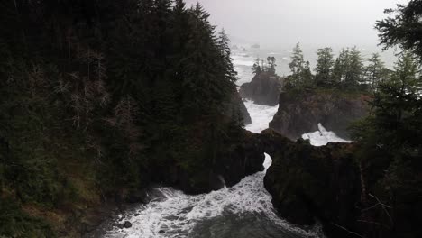 Waves-Crash-Along-An-Oregon-Cove-Coastline-On-A-Foggy-Day