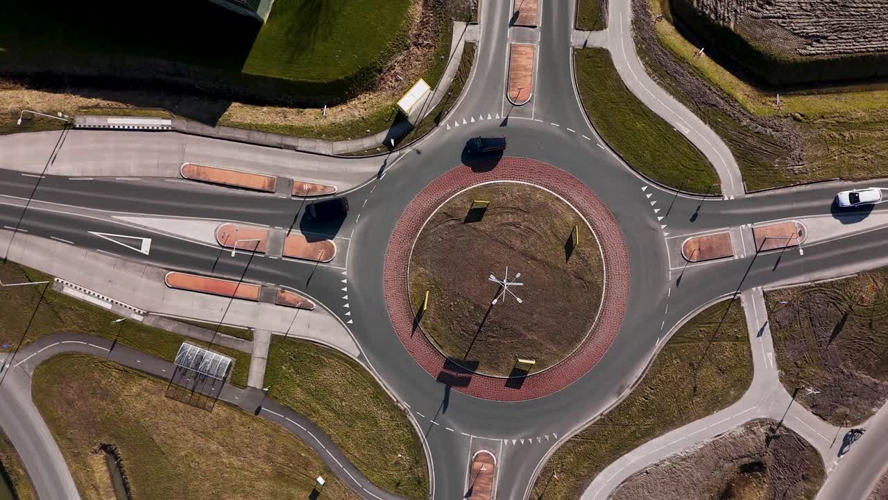 Aerial Top-Down View of Cars Driving Through a Roundabout