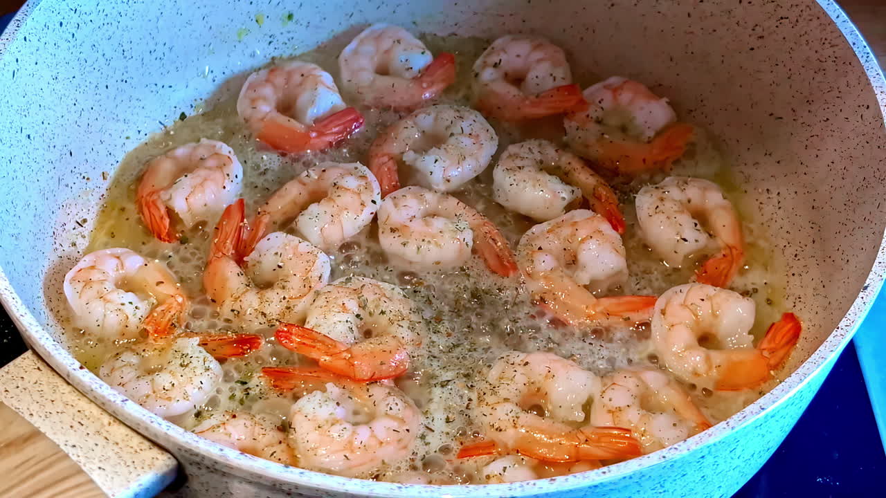 Salt and pepper are added to the shrimps frying in oil. Close up shot.