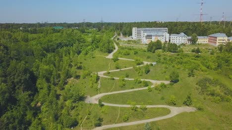 hairpin-curves-on-green-hill-at-houses-on-sunny-day-aerial