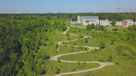 hairpin curves on green hill at houses on sunny day aerial