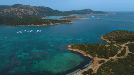 aerial of an idyllic natural rocky coast beach sandy bay on the tourist vacation island sardinia in italy with sun, clear blue turquoise and calm water close to costa rei