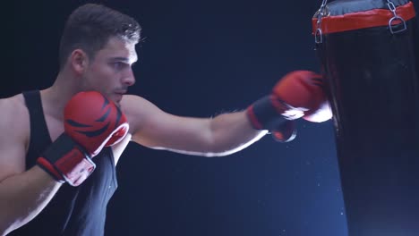 strong athlete punches punching bag in dusty gym. cinematic boxing scene.