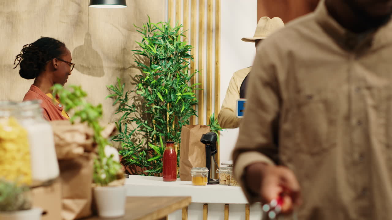 афроамериканский продавец готовит сумку с продуктами для клиента