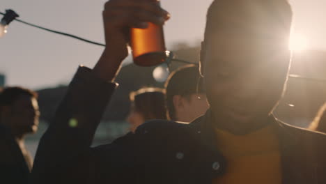 young woman dancing group of diverse friends hanging out together enjoying rooftop party at sunset drinking alcohol having fun on weekend celebration