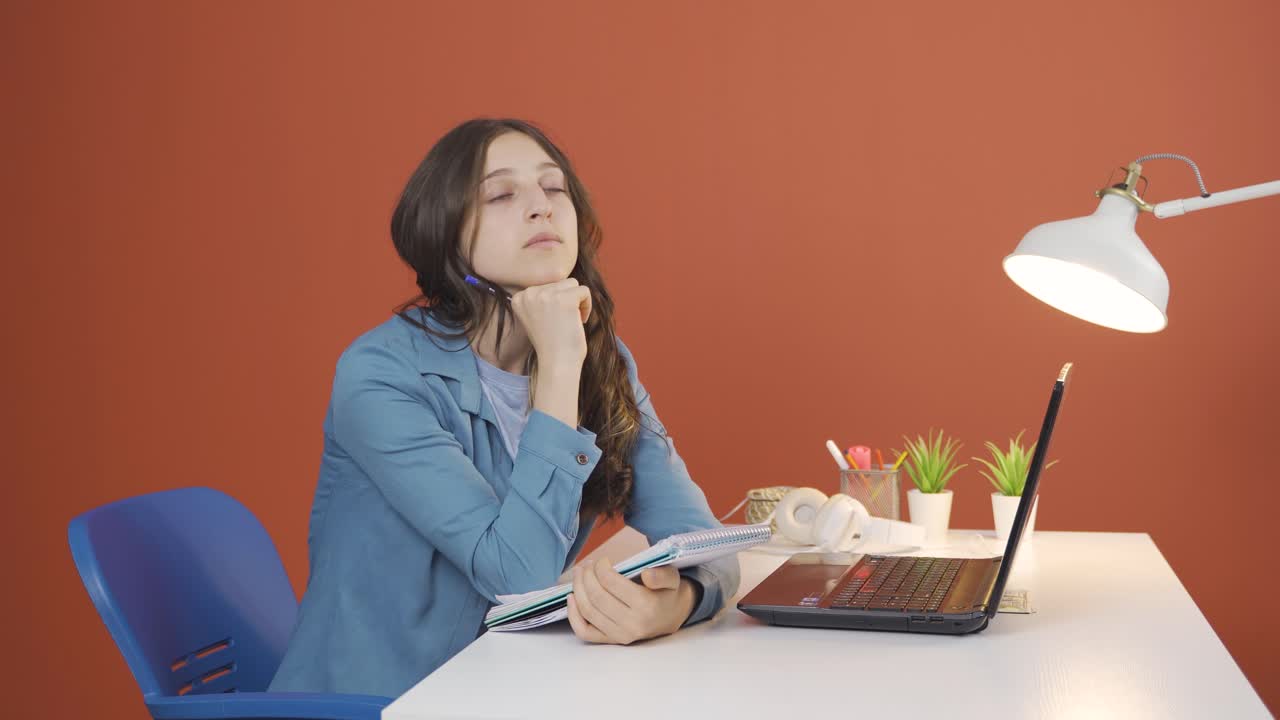 una mujer joven con un cuaderno piensa y toma notas.
