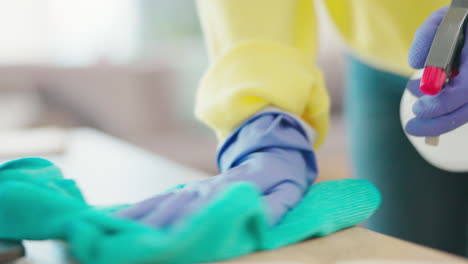 hands of woman cleaning table with spray