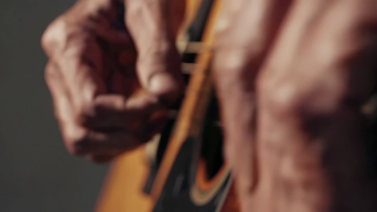 primer plano de manos tocando la guitarra acústica