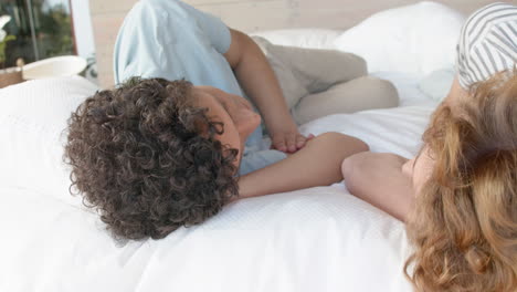 young biracial gay couple resting in a comfortable home setting, with copy space