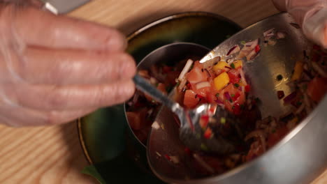 tartar de atún - chef vertiendo la mezcla de atún crudo y verduras picadas en una moldeadora de acero inoxidable