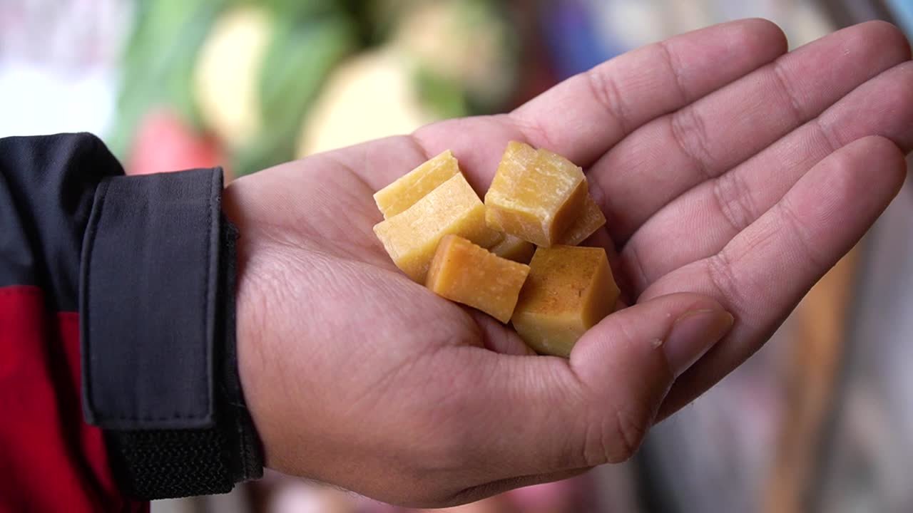 un hombre que sostiene chhurpi nepalés en su mano en katmandú, nepal