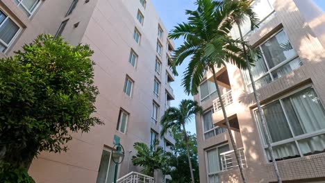 a high-rise building surrounded by lush tropical plants